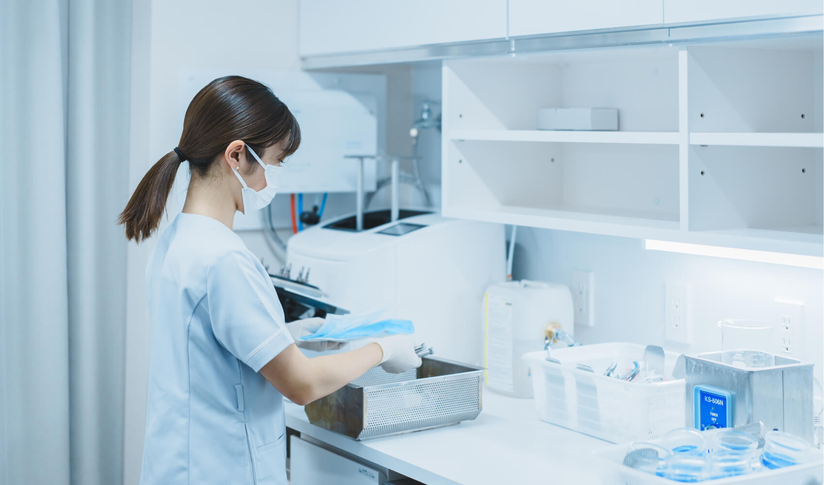 ソラハレ歯科・矯正歯科の滅菌・消毒スペースで、女性スタッフが医療器具を滅菌処理している。衛生管理の徹底が伝わるクリーンな環境。