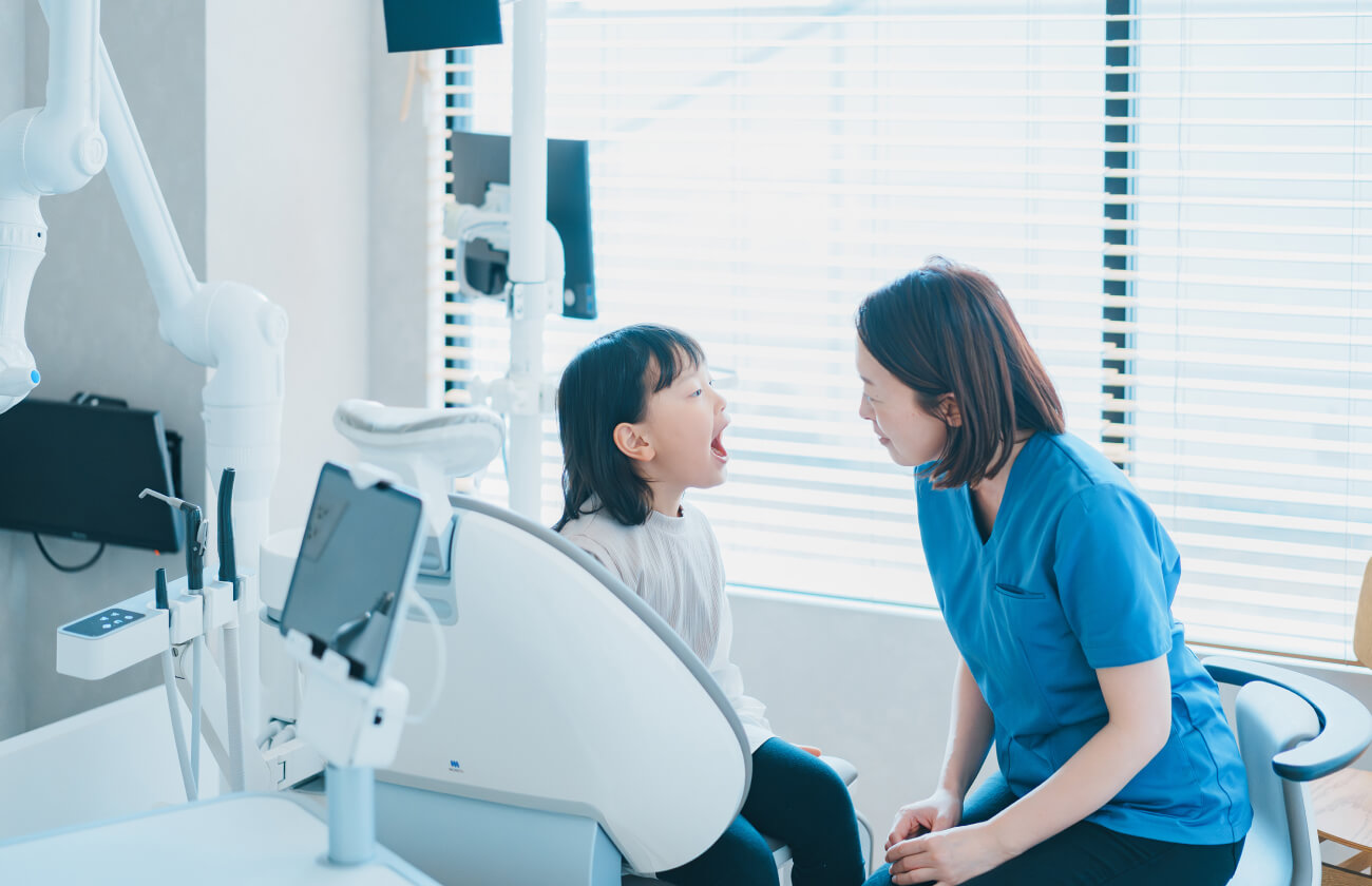 お子様が怖がらないよう、目線を合わせてコミュニケーションを取りながら診察する様子