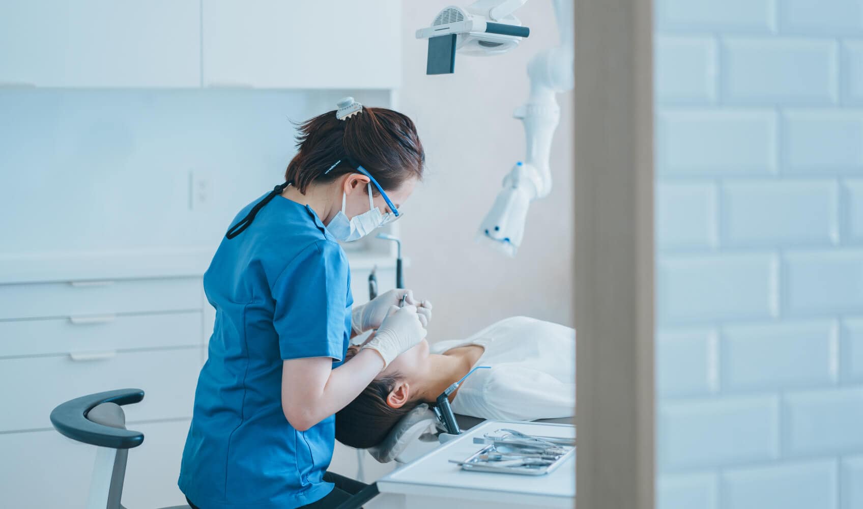 最新の設備が整った診察室で、患者さんの口内を真剣な表情で確認する歯科医師