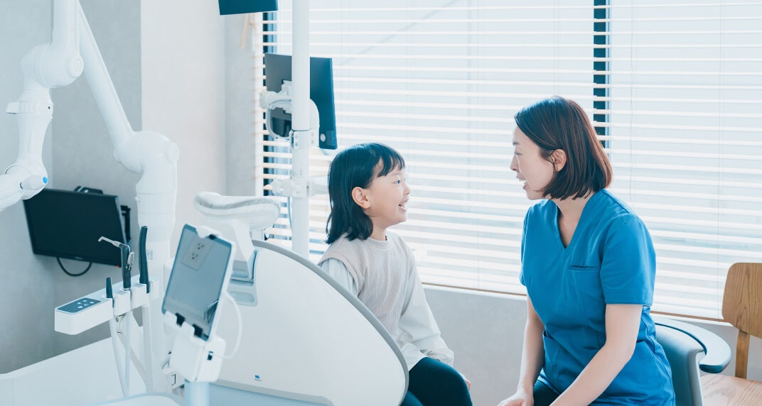 お子様が歯医者を怖がらずに済むよう、目線を合わせて丁寧にコミュニケーションをとる歯科医師
