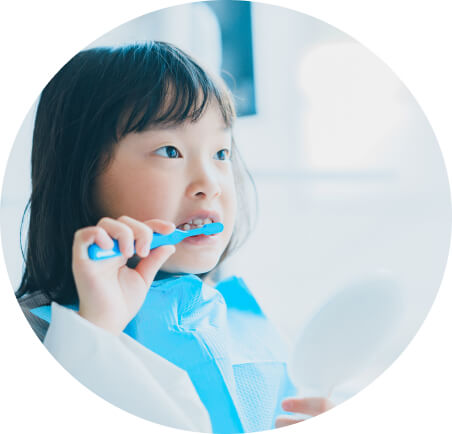 鏡で自分のお口を確認しながら、正しい歯の磨き方を練習する子供