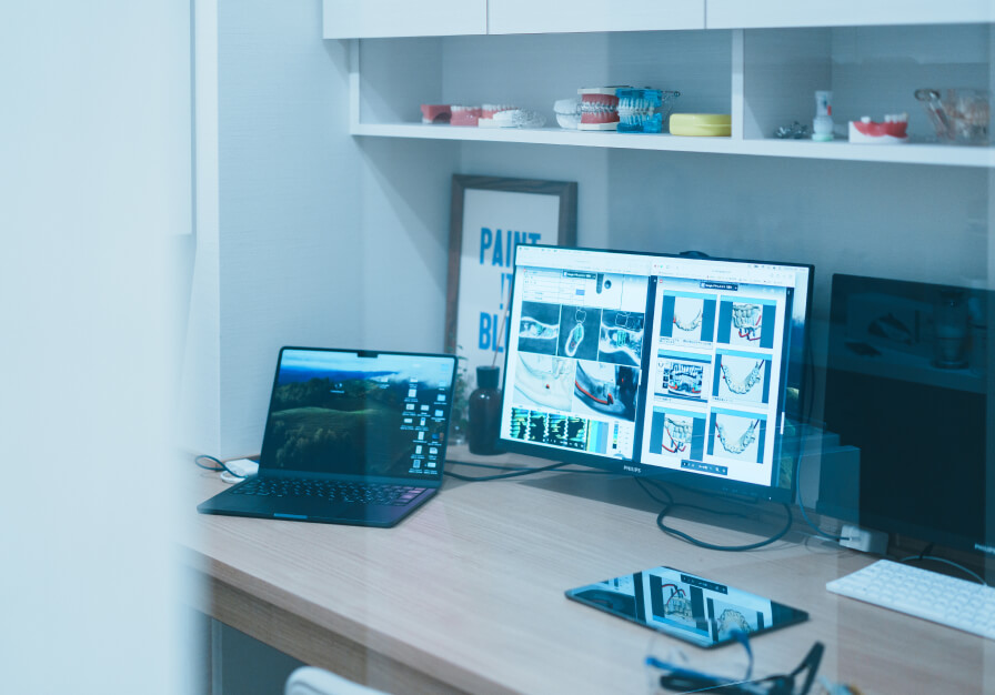 患者様に最適な治療計画を提案するため、CTやレントゲン等のデータをPCで分析する様子