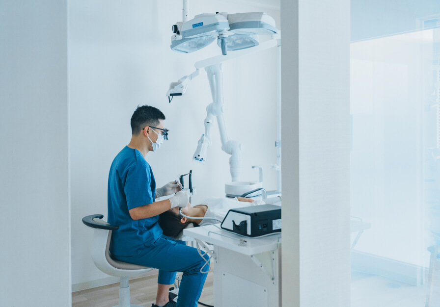 歯科医師が、患者様にインプラントを埋め込むための外科手術を行っている風景